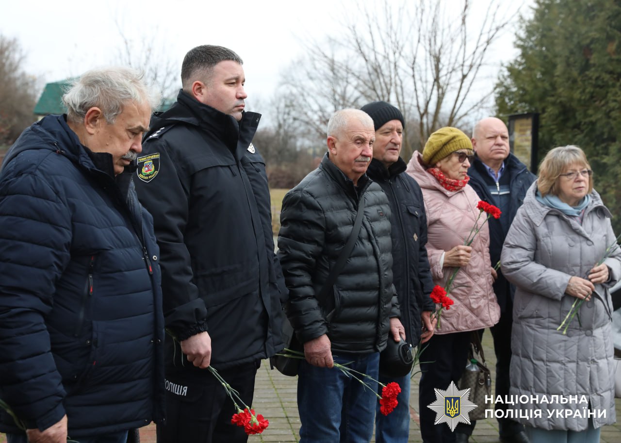 На фото учасники заходу із квітами під час проведення молебня.