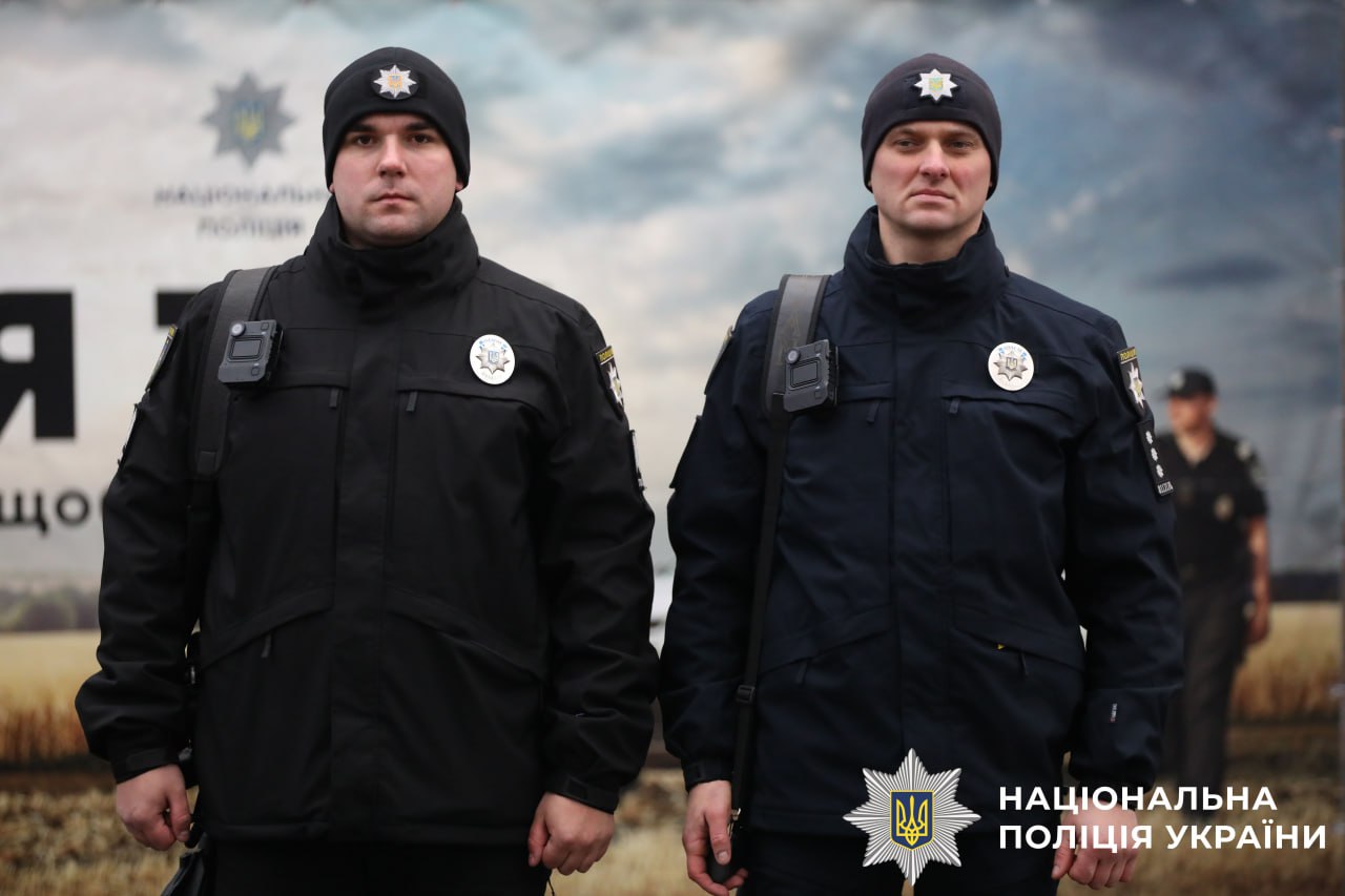 На фото поліцейські офіцери громади біля автомобіля.