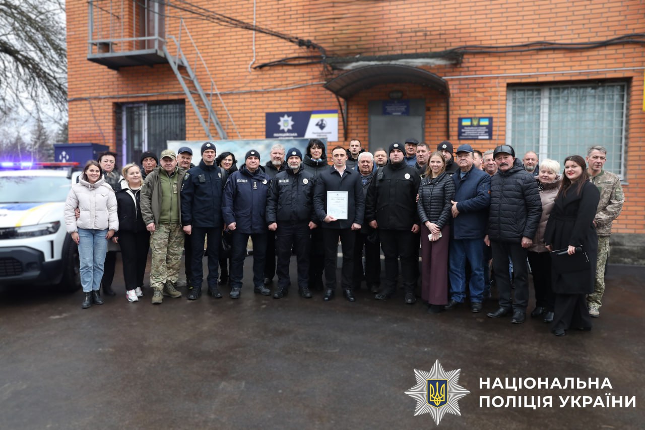 На фото всі учасники відкриття поліцейської станції. Загальне фото на фоні поліцейської станції.