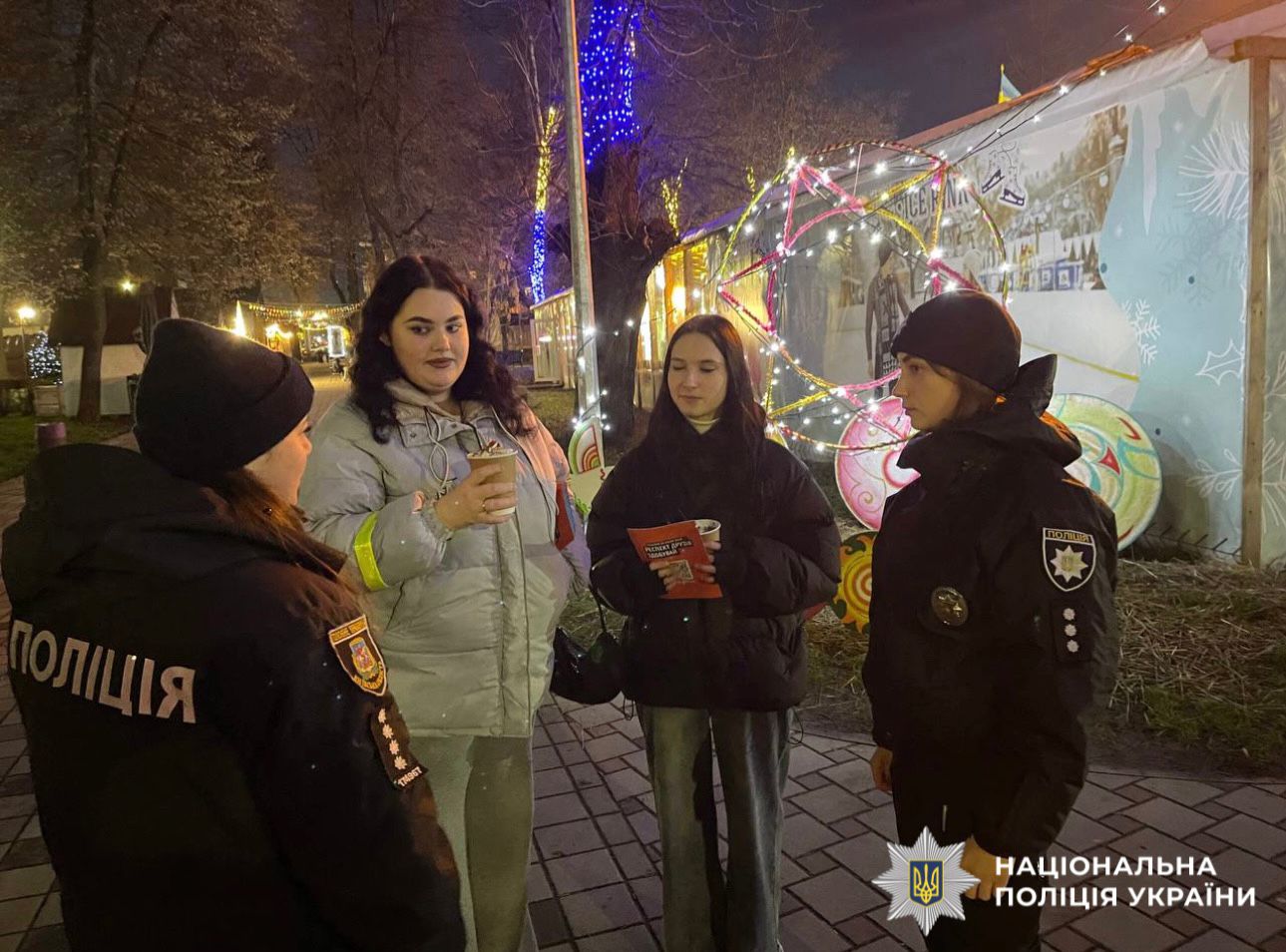 На фотографії зображено поліцейських та підлітків під час спілкування про обов'язкове носіння світлоповертальних елементів.