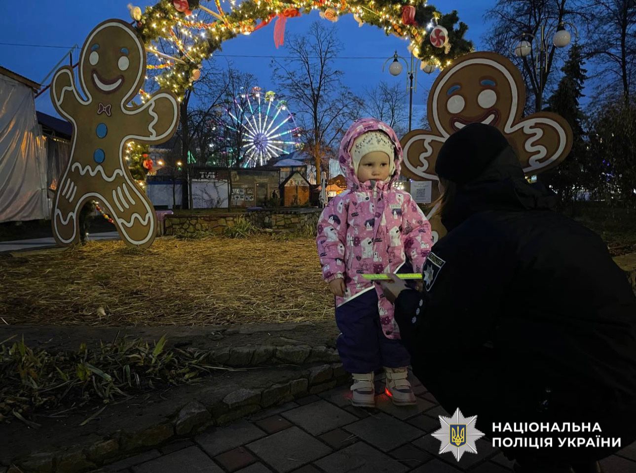 На фотографії зображено поліцейську та дитину під час спілкування про обов'язкове носіння світлоповертальних елементів.