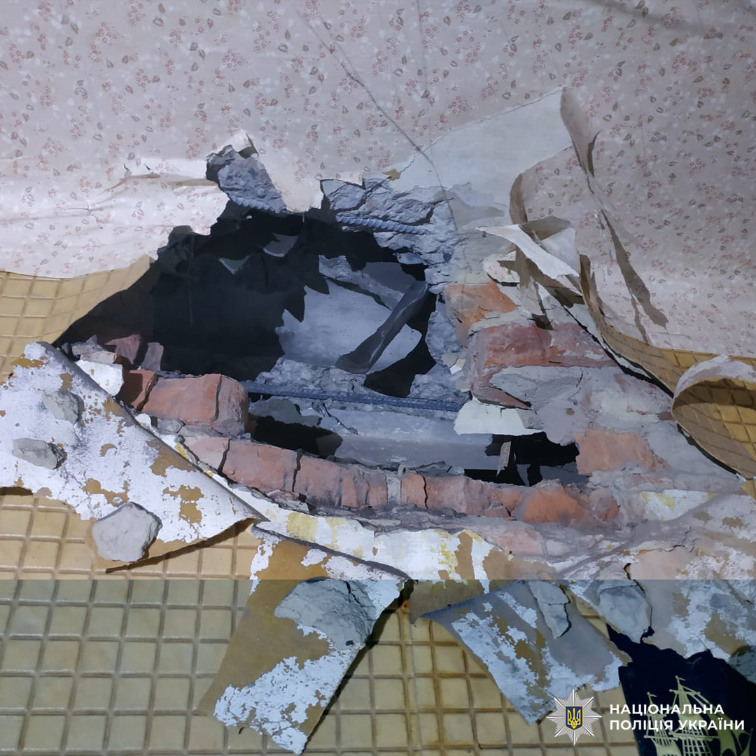 Стіна з великим отвором, видно цеглу, бетон та залишки шпалер.