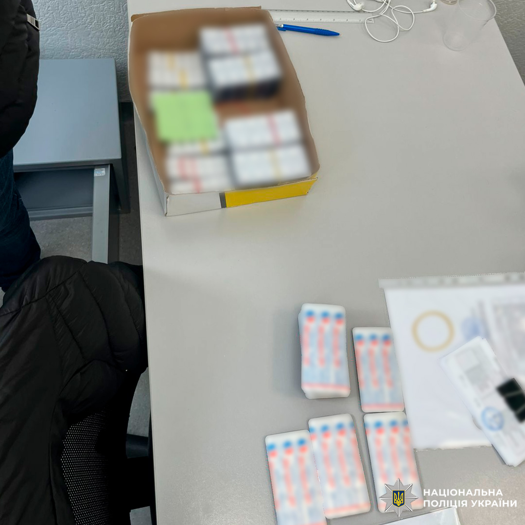 Речові докази: коробка з блістерами таблеток та упаковки препарату, задокументовані на столі разом із канцелярськими предметами та документами.