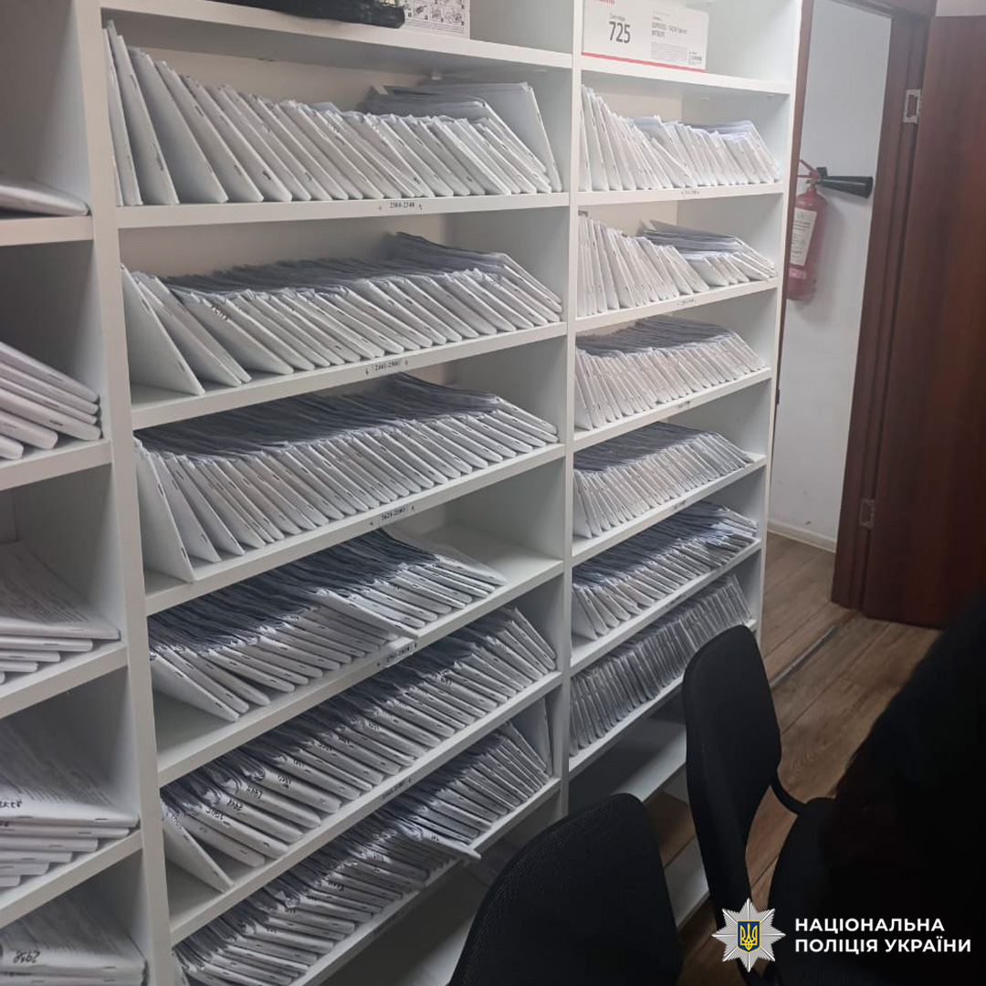 Речові докази - документи у білих конвертах, розміщені на стелажах.