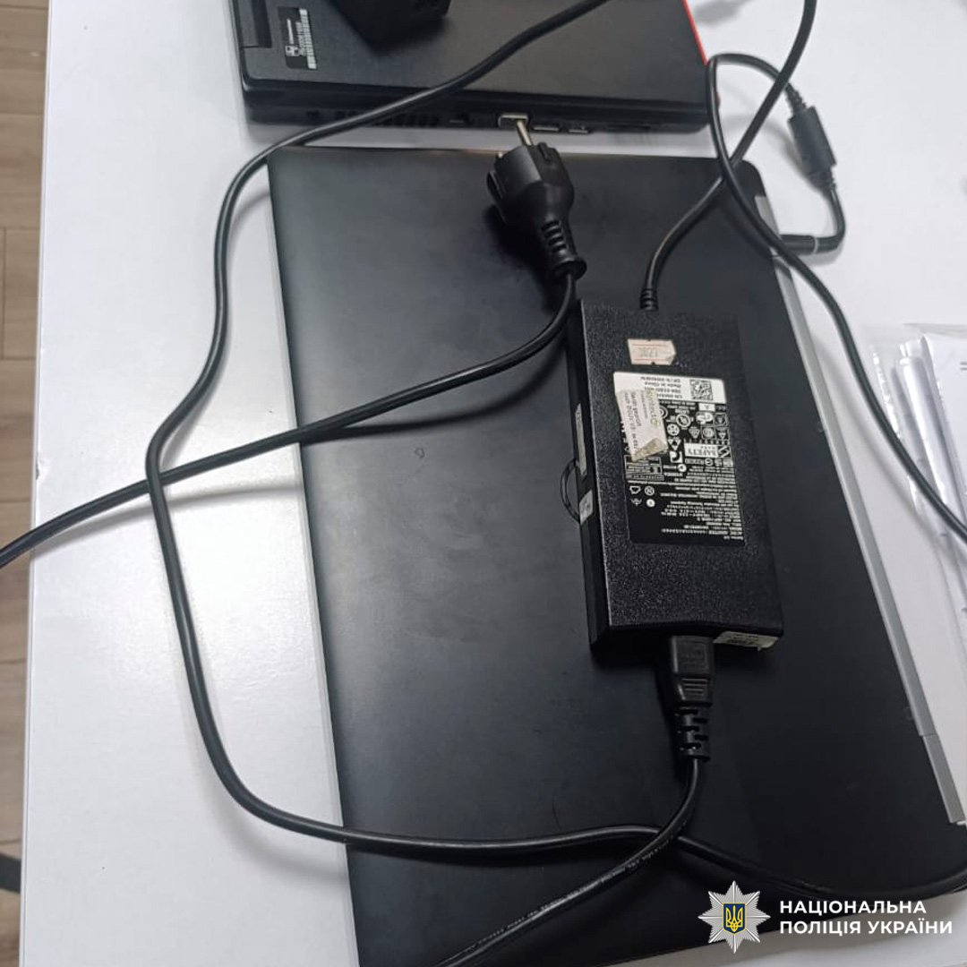 Блок живлення та додатковий електронний пристрій, задокументовані на столі разом із супровідними документами.