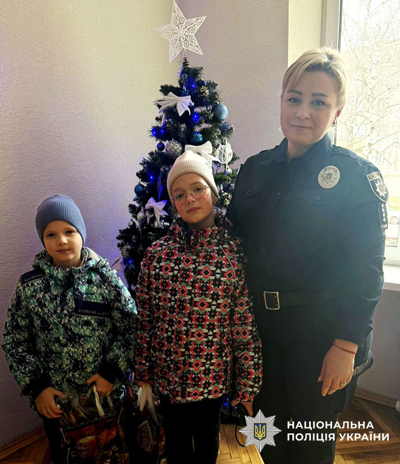 На фото поліцейська та діти.