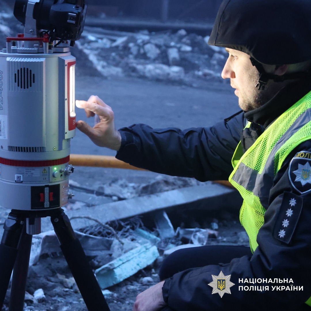 Поліцейський використовує сканер серед уламків.