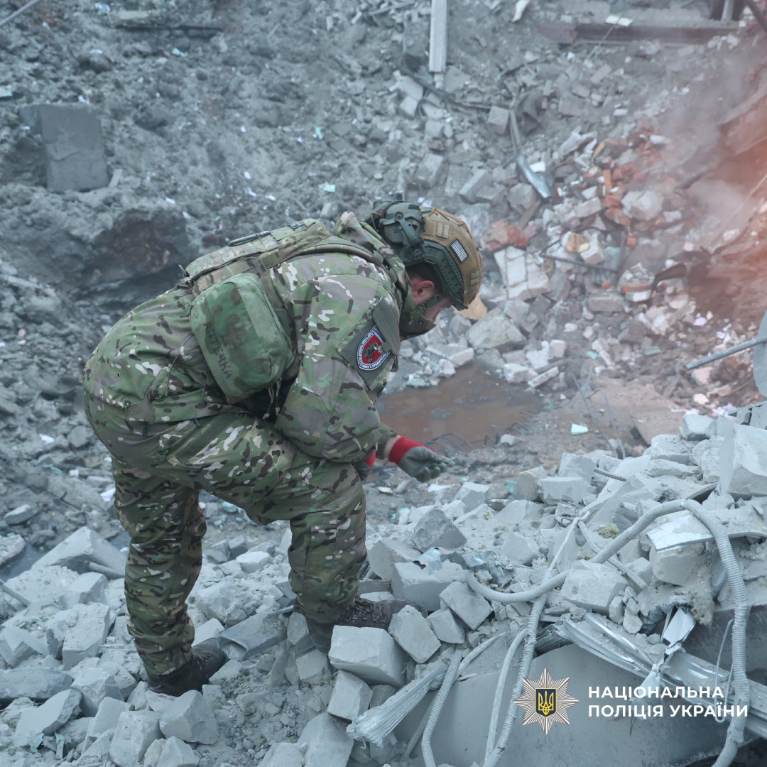 Поліцейський у камуфляжі оглядає уламки.