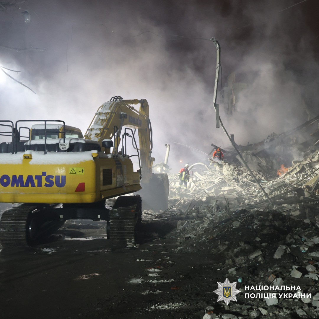 Екскаватор серед диму та уламків після вибуху.