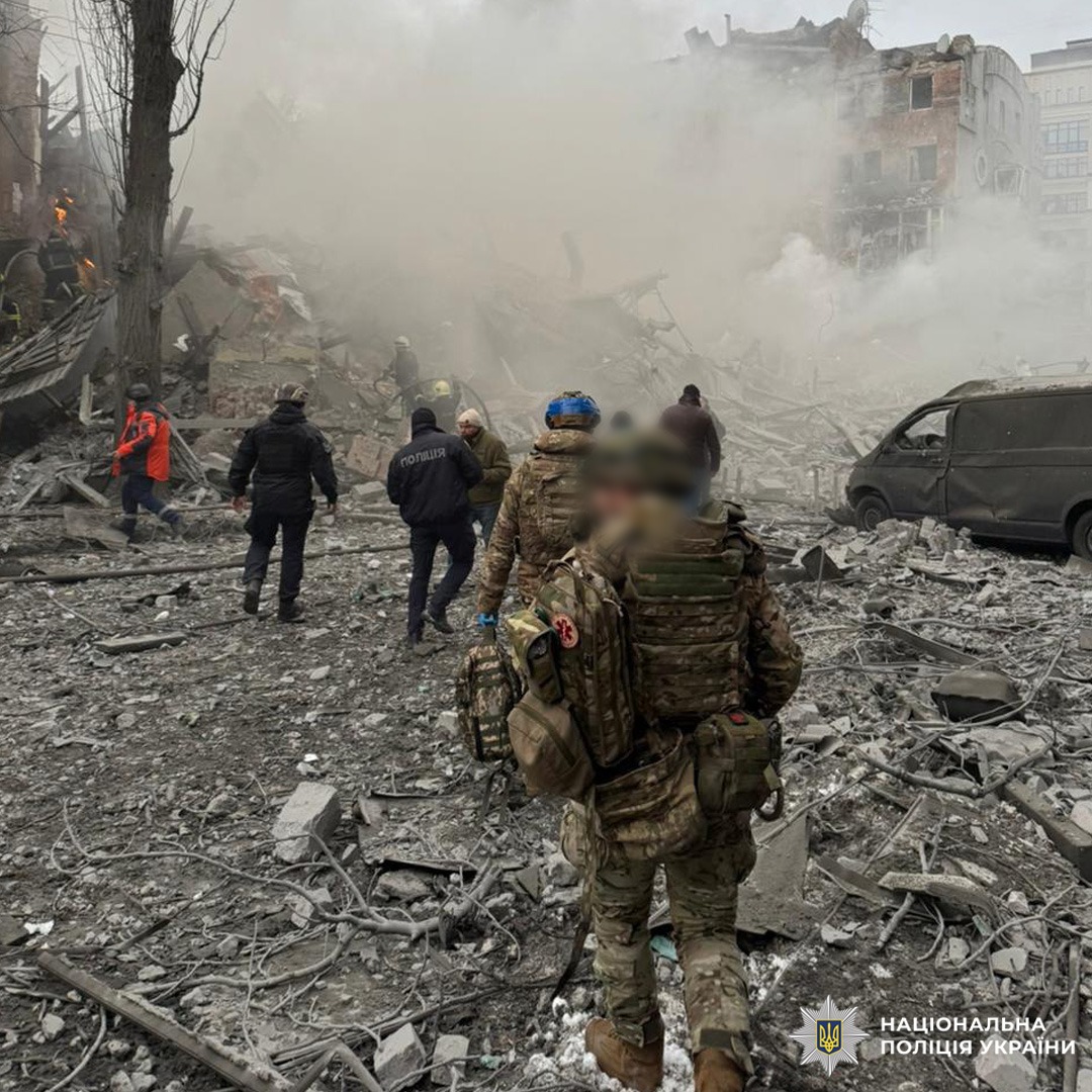 Пошкоджена будівля з руйнуваннями та димом; на місці військові й рятувальники.