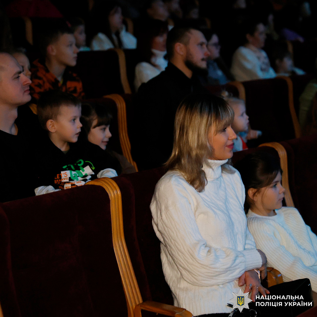 Глядачі, серед яких діти та дорослі, уважно дивляться виставу в залі театру.