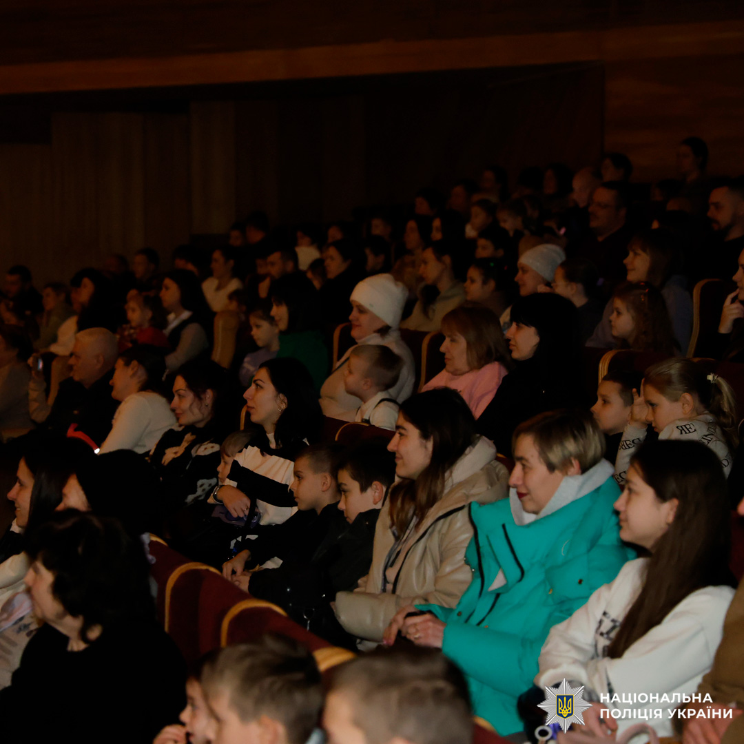Глядачі, серед яких діти та дорослі, уважно дивляться виставу в залі театру.