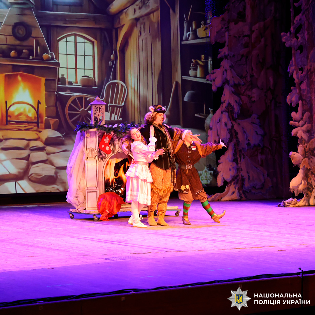 Театральна вистава з різдвяними декораціями, актори у костюмах на сцені.