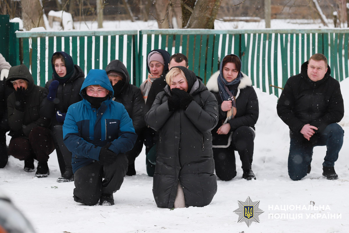 Люди на колінах перед загиблим Героєм