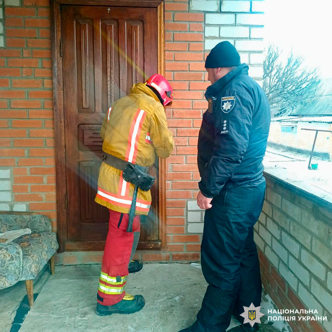 Пожежник і поліцейський здійснюють спільні дії біля дверей житлового будинку під час виїзду на виклик.