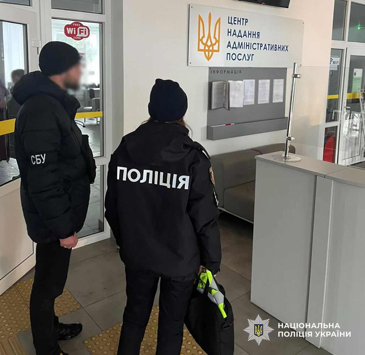 поліцейська та співробітник УСБУ стоять у приміщенні центру надання адмінпослуг