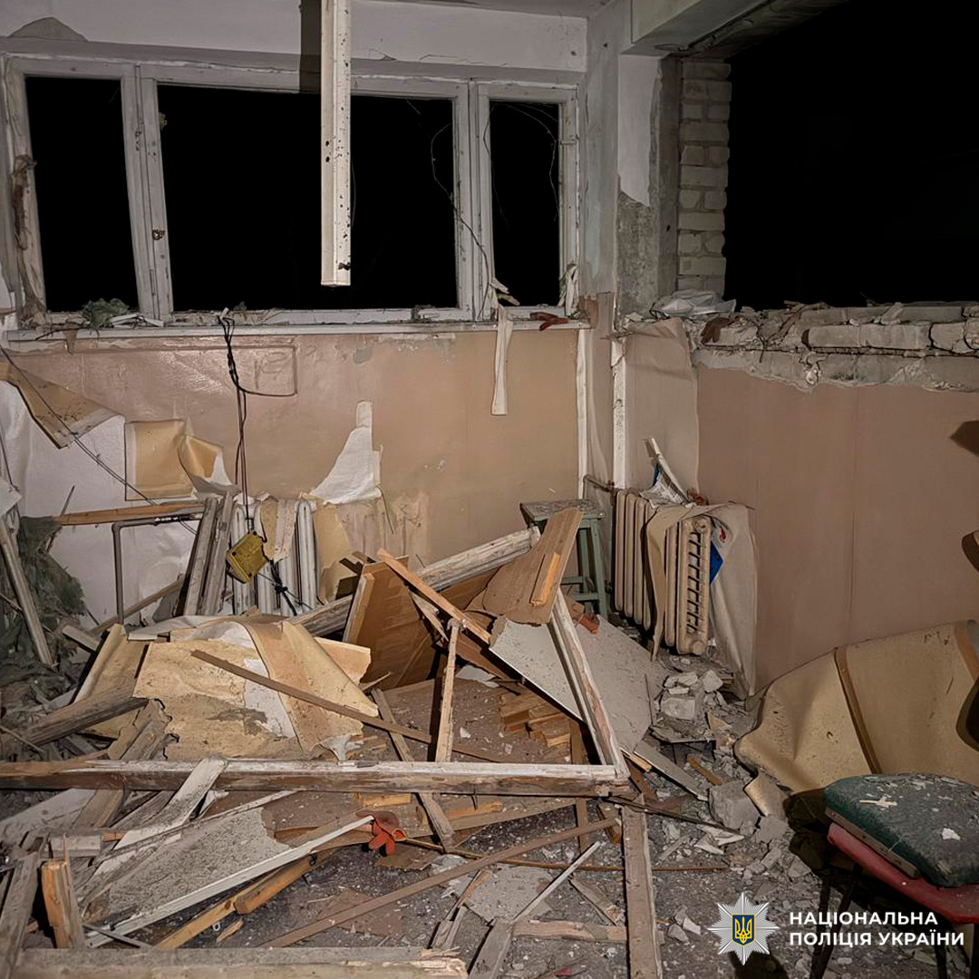 Зруйноване приміщення з вибитими вікнами та уламками меблів після вибуху.