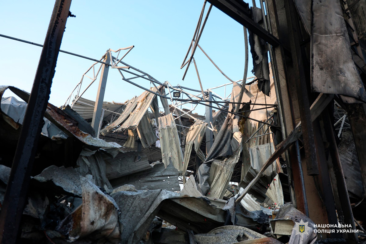 Зруйнована металева конструкція з обваленим дахом та уламками на землі.