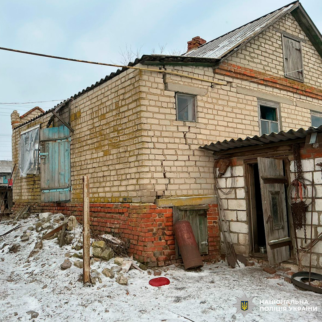 Пошкоджений житловий будинок із тріщиною в стіні, зимовий пейзаж.