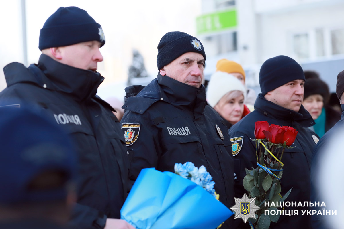 На фото працівники поліції тримають квіти