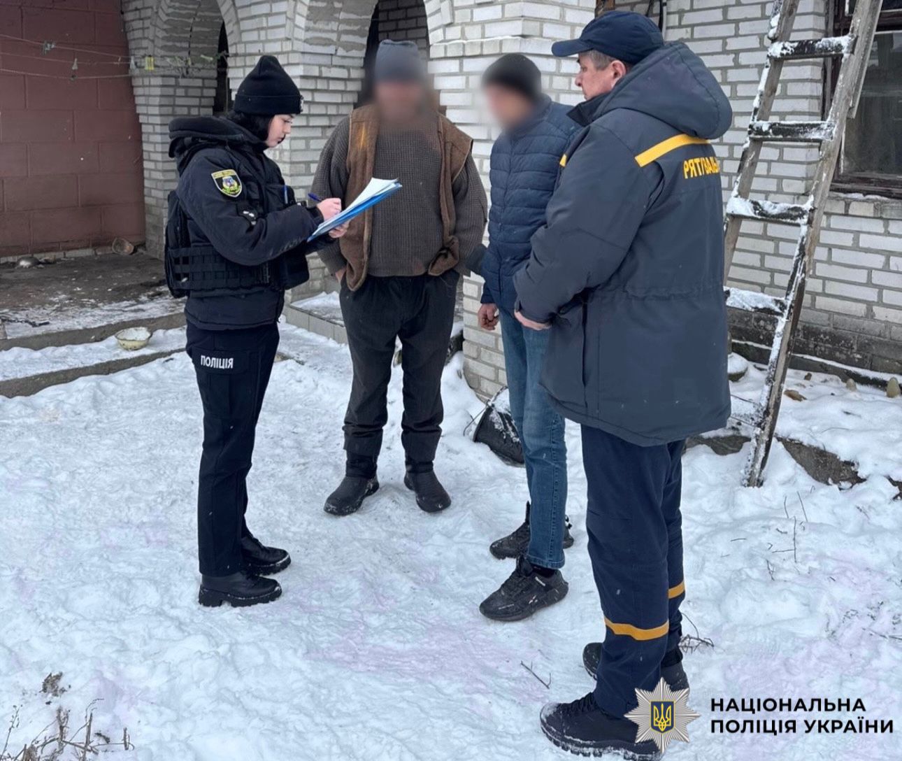 На фотографії зображено поліцейську та рятувальника, які працюють на місці події, де відбулась пожежа.