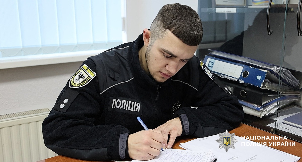 поліцейський в кабінеті записує матеріали справи