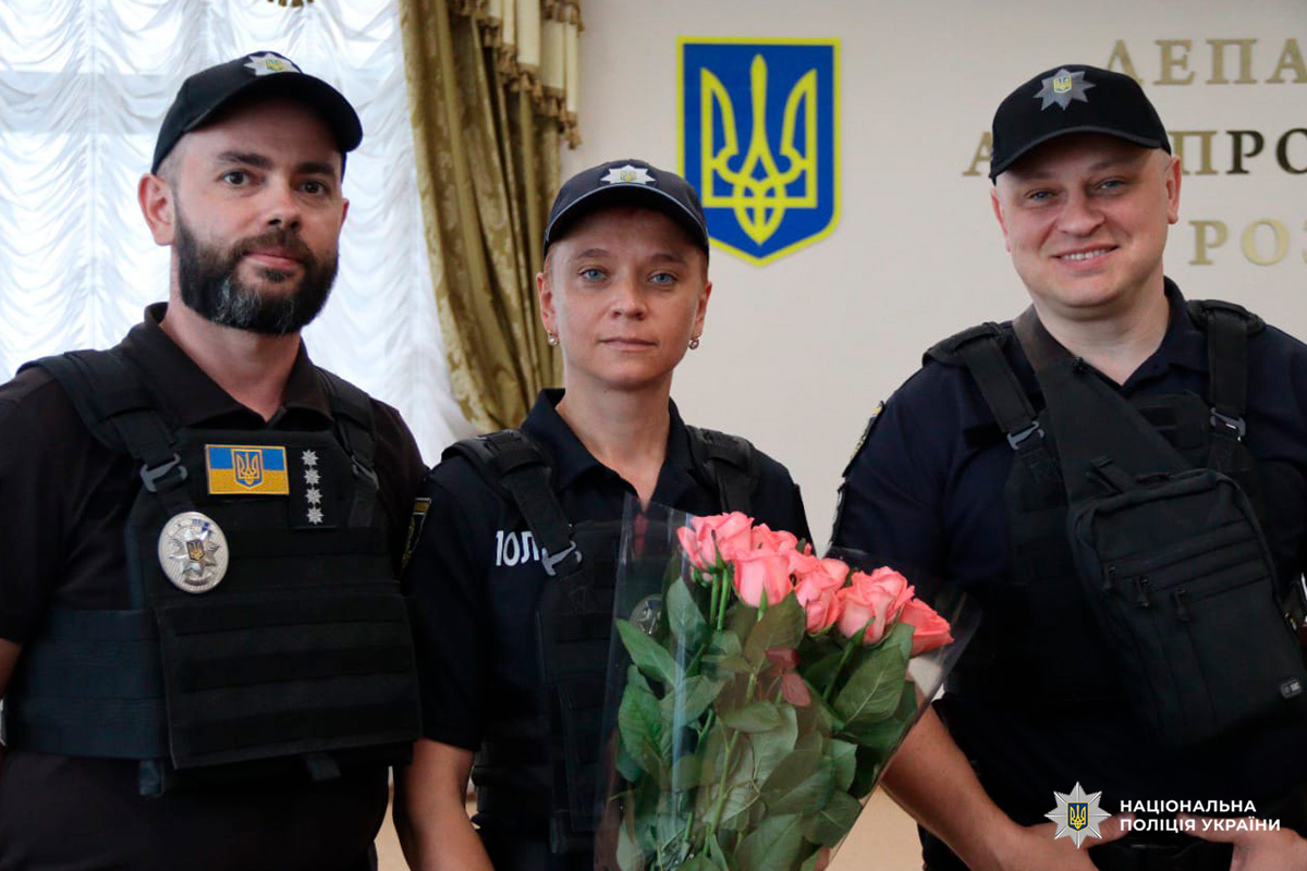 Офіцери Національної поліції України під час урочистої події, де колегу відзначають квітами.