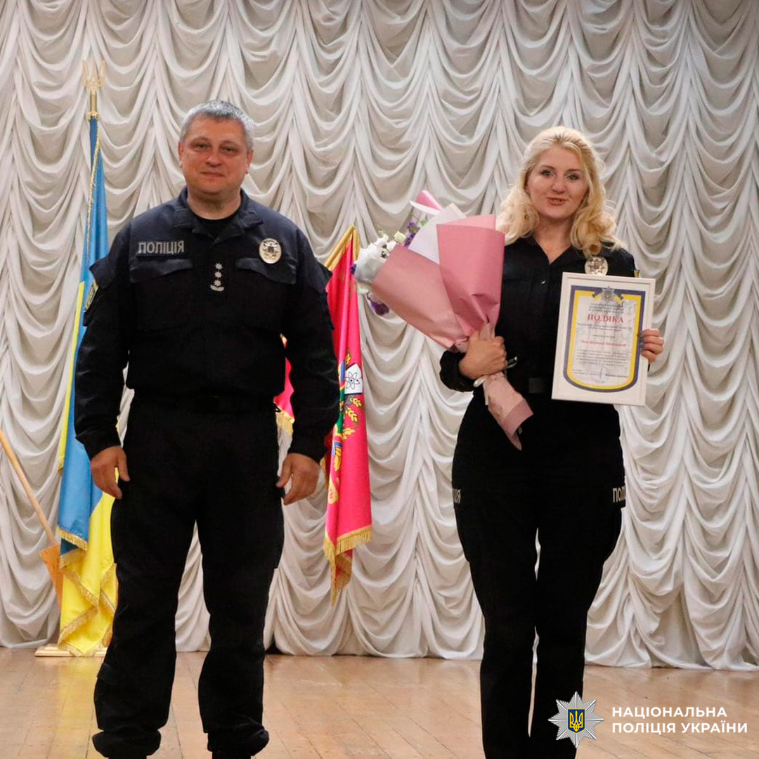 Поліцейська отримує подяку та квіти під час урочистої церемонії вшанування.