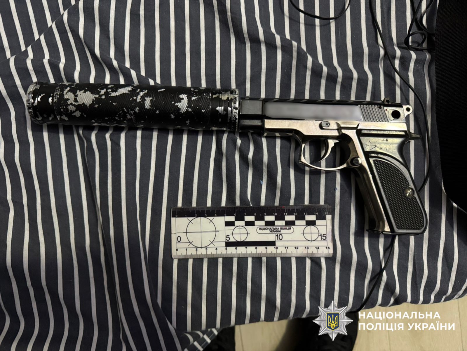 На фотографії зображено вилучений під час обшуку пістолет.