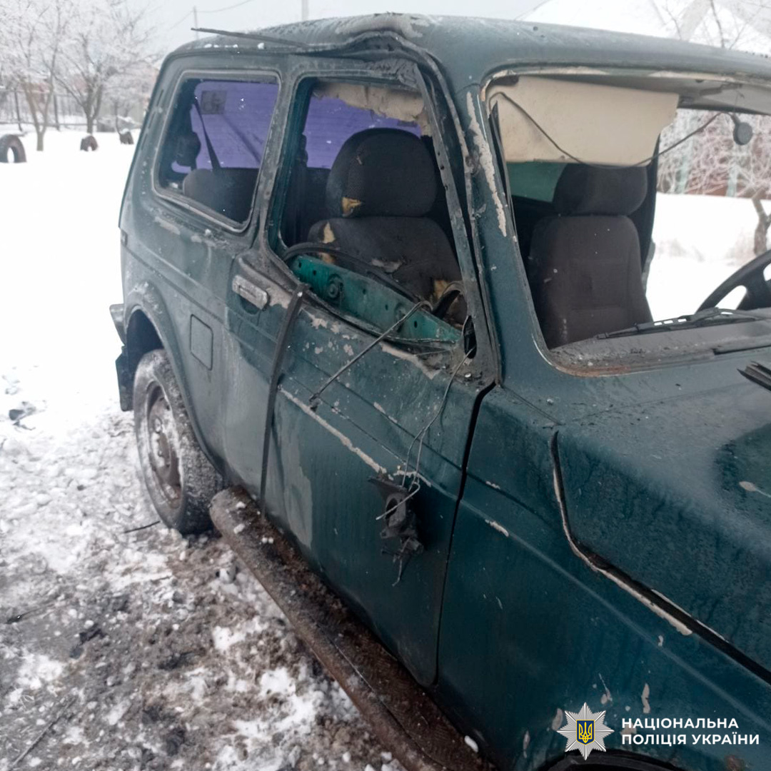 Автомобіль із пошкодженим боковим вікном та дзеркалом стоїть серед снігу.