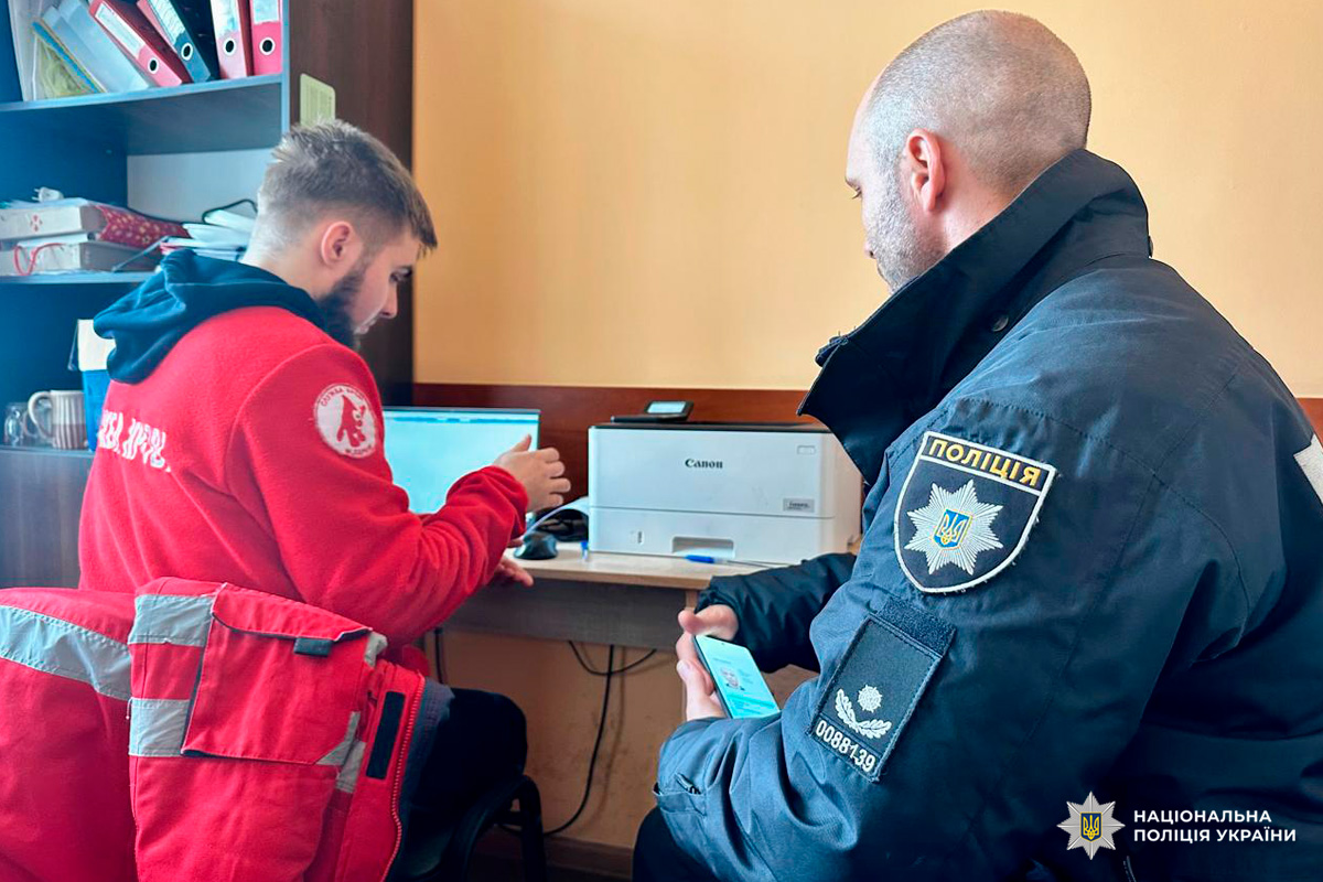 Правоохоронець у формі та представник служби порятунку взаємодіють у робочому кабінеті.