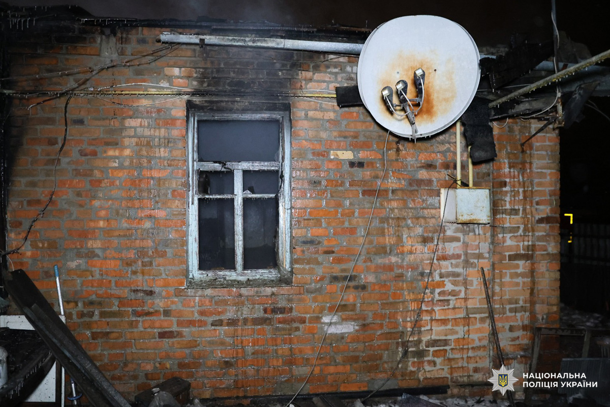 Обгоріла цегляна стіна будівлі з пошкодженим вікном.