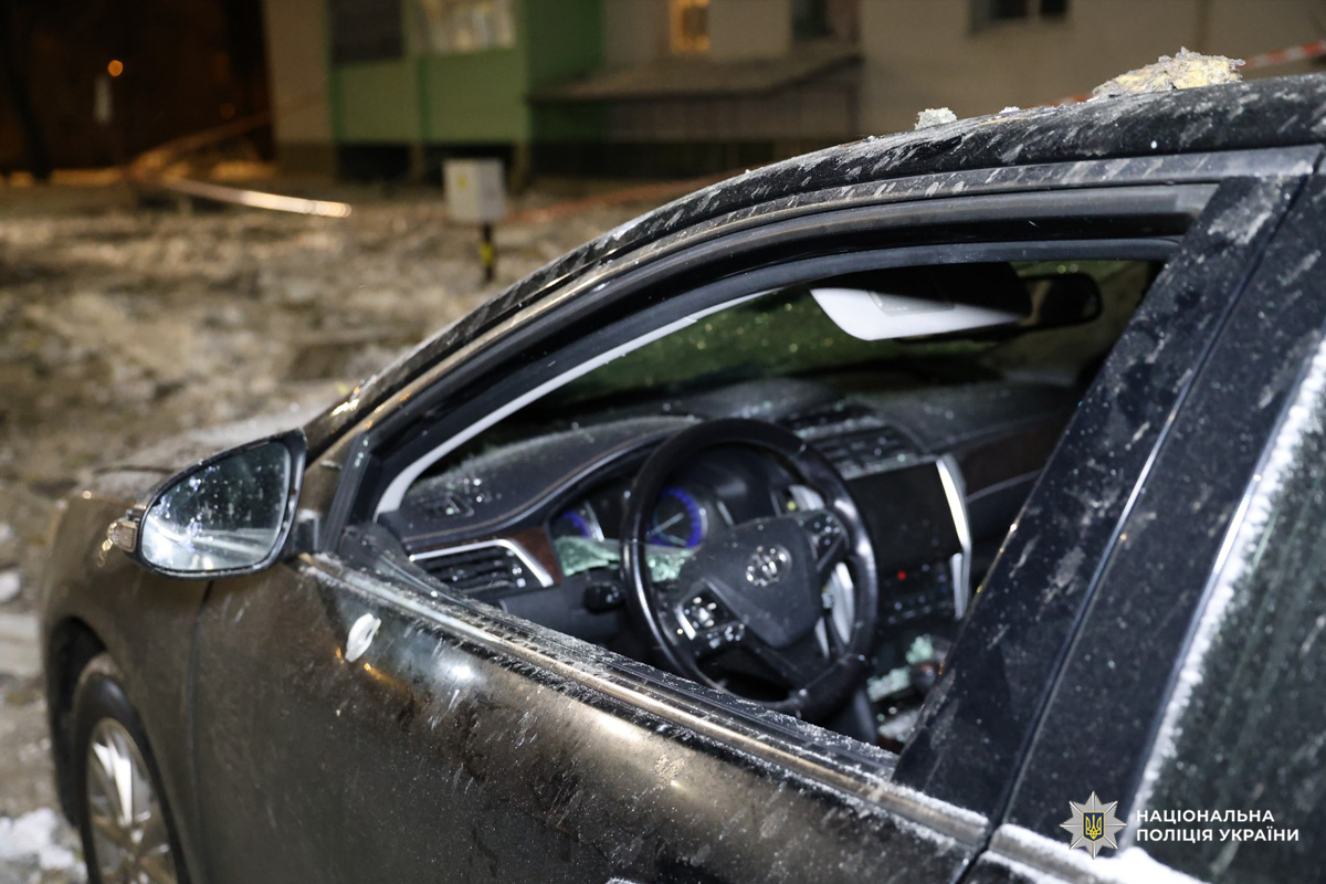 Пошкоджене авто з розбитим вікном на засніженій вулиці.