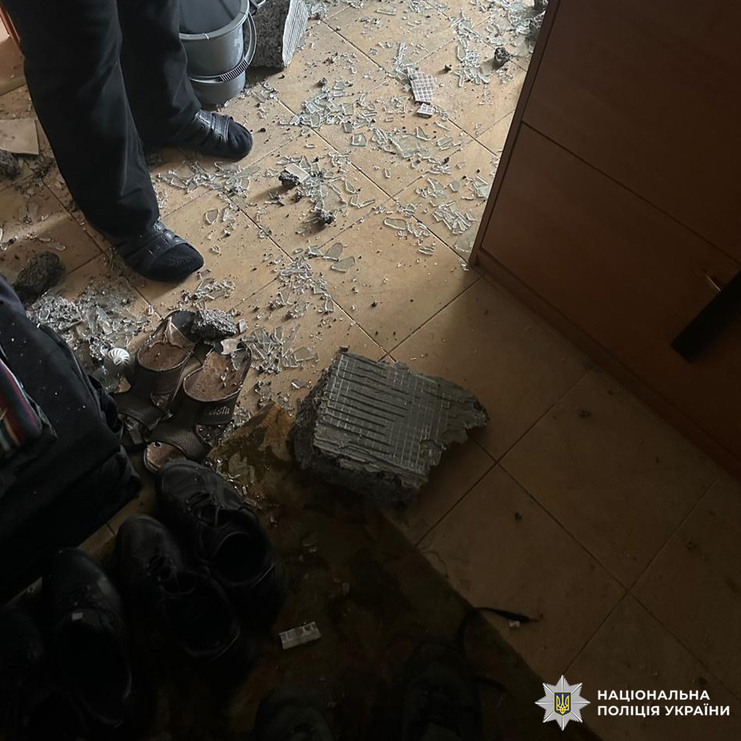 Пошкоджене приміщення з великим шматком бетону серед сміття.