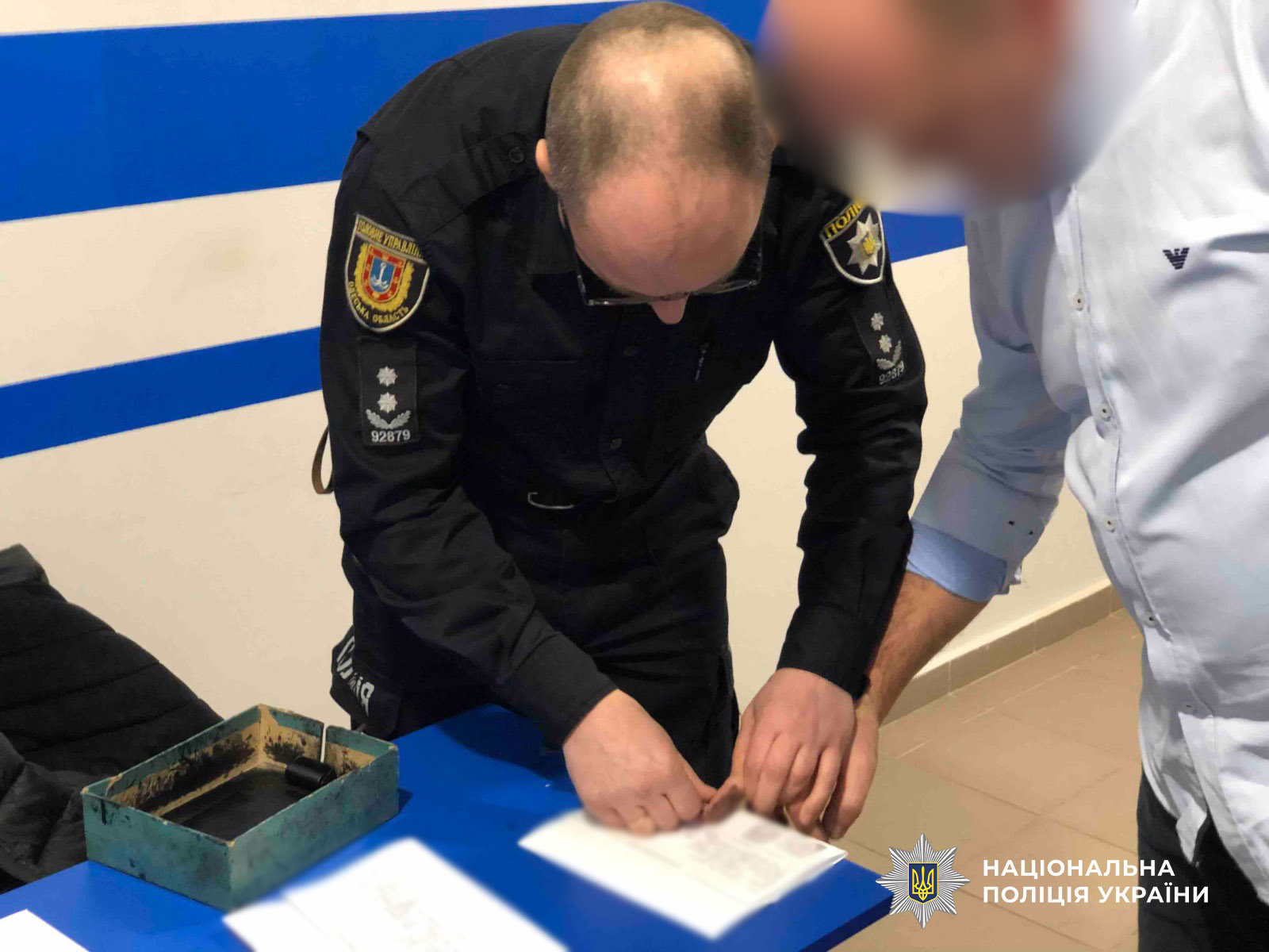 експерт-криміналіст робить дактилоскопію для ідентифікації особи підозрюваного