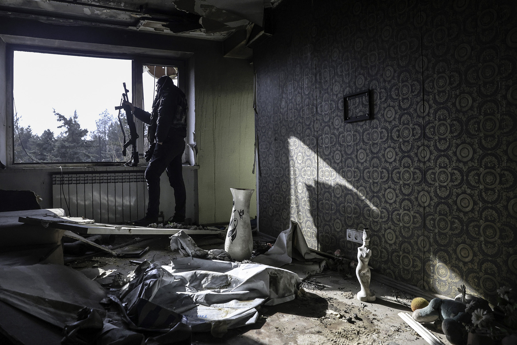 Поліцейський спостерігає за небом крізь вікно квартири, зруйнованої окупаційною армією рф. Місто Оріхів. Лютий 2025 року.