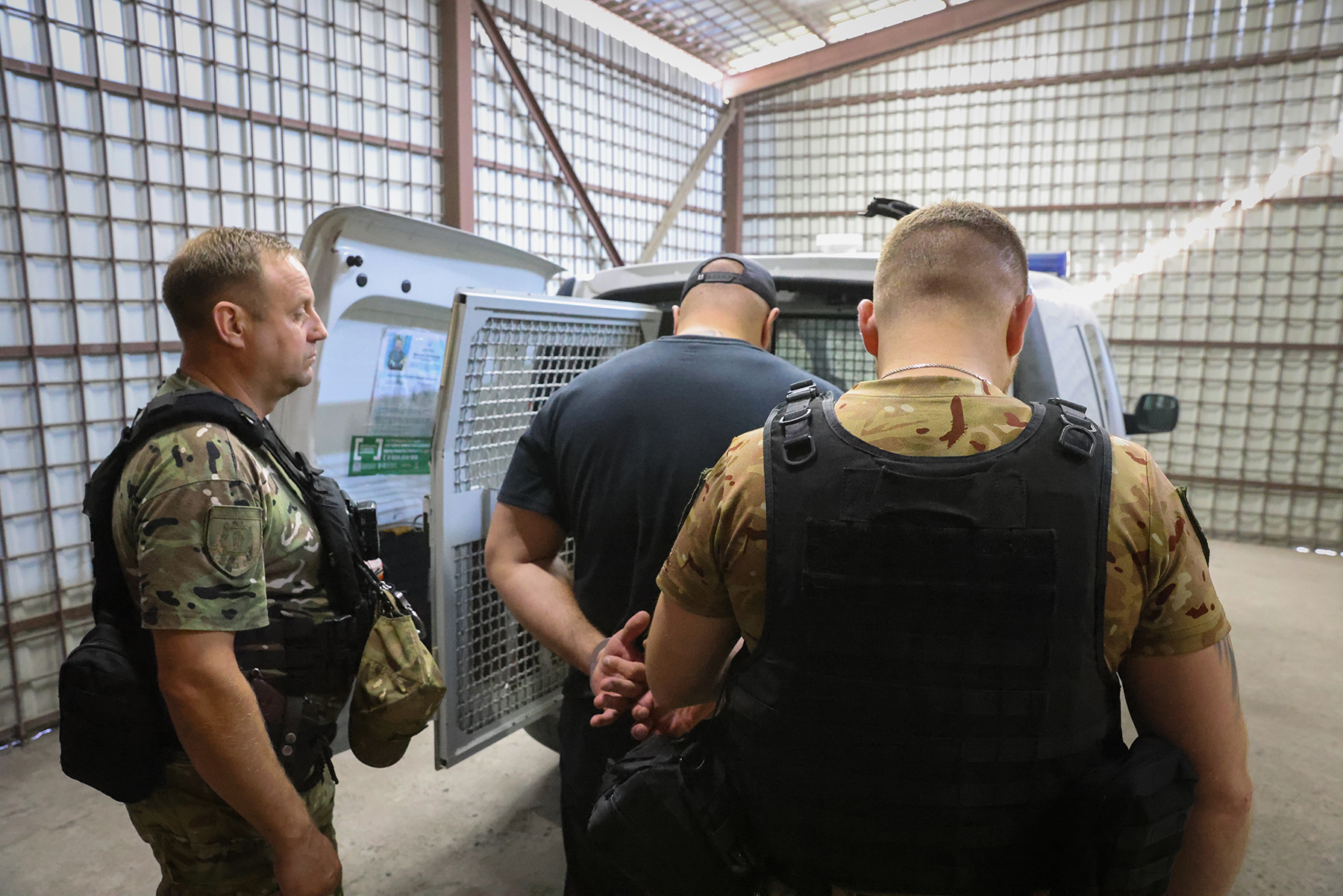 Поліцейські конвоюють організатора замаху на вбивство до судової установи для обрання йому запобіжного заходу. Місто Запоріжжя. Вересень 2025 року.