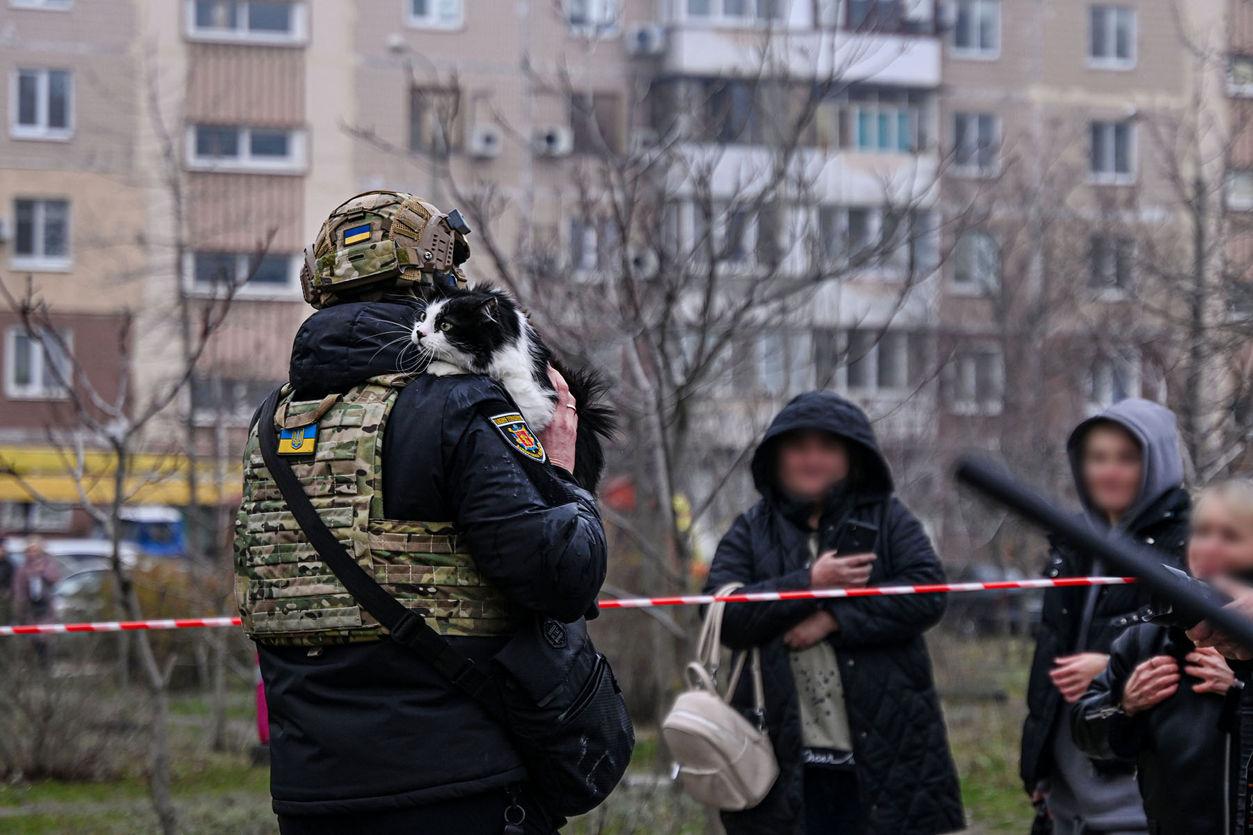 Запорізький поліцейський тримає кота, врятованого на місці російського авіаудару по багатоповерхівці в місті Запоріжжя. Грудень 2025 року.