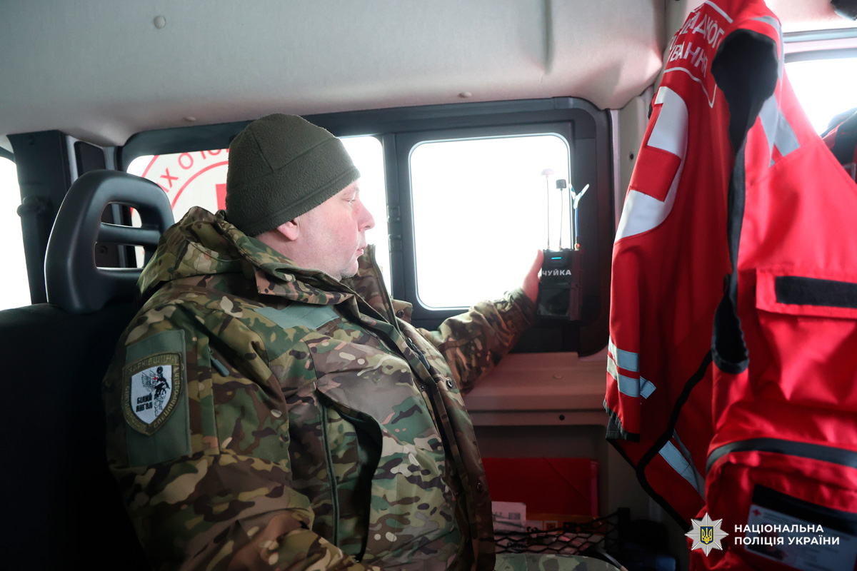 Поліцейський у камуфляжі перевіряє обладнання «Чуйка» у транспортному засобі