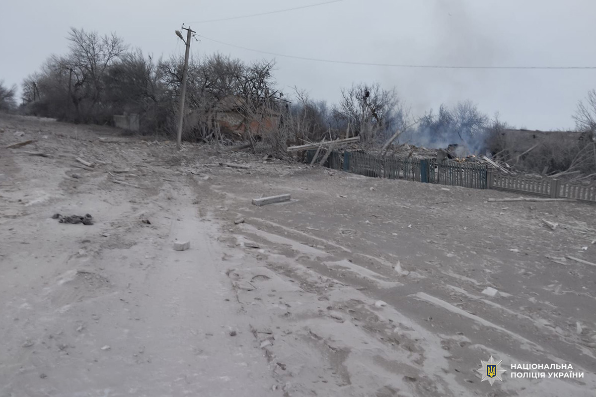 Зруйнована будівля після вибуху, територія вкрита уламками та димом.