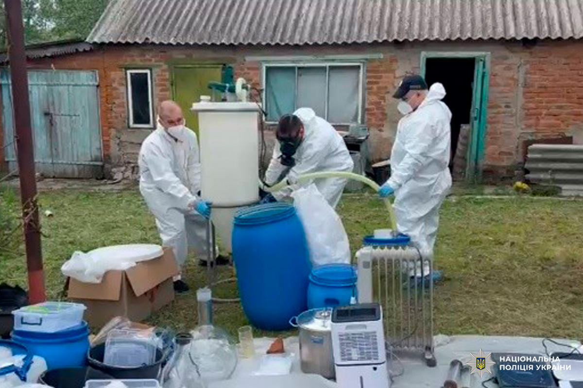 Працівники Національної поліції України у захисних костюмах проводять операцію з вилучення хімічних речовин.