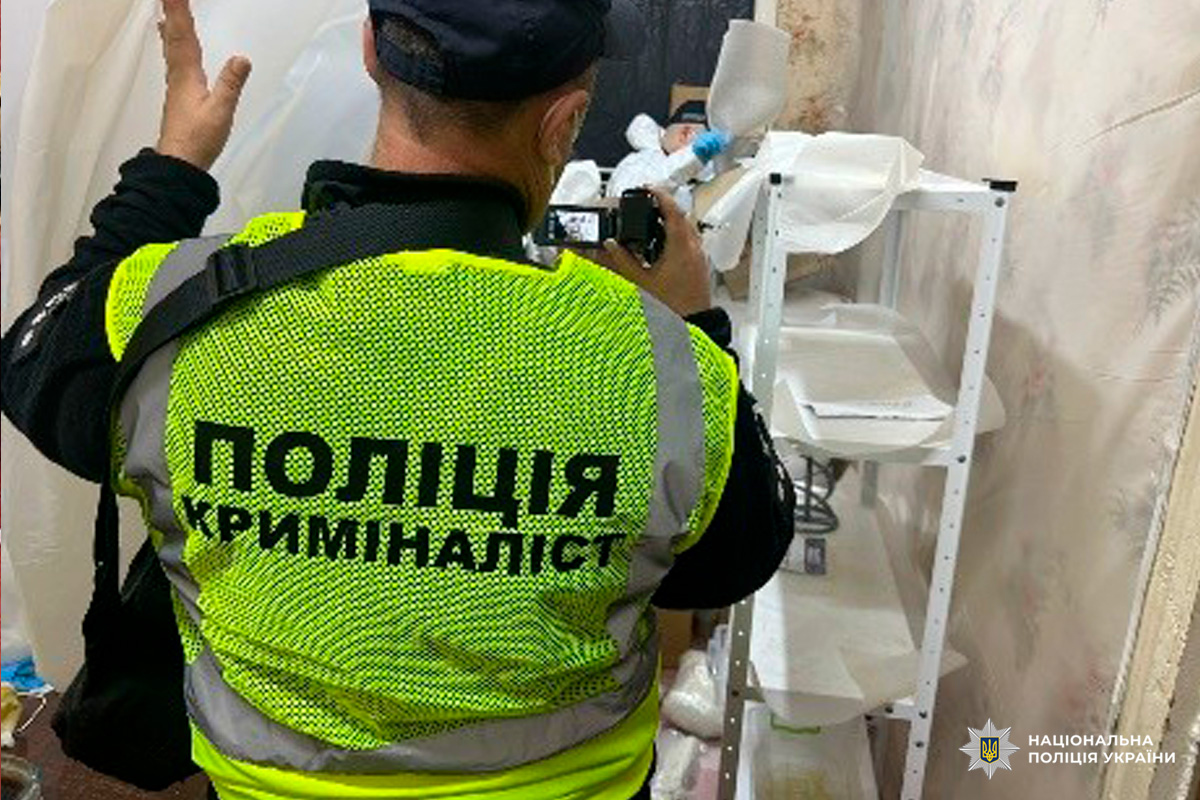 Криміналіст Національної поліції України фотографує речові докази у приміщенні.