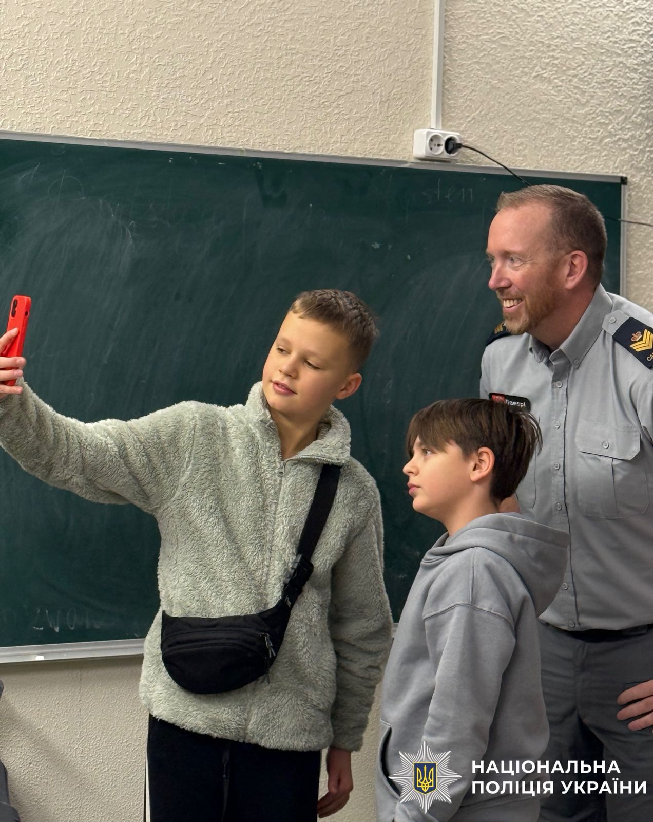 На фото зображений іноземний поліцейський, який фотографується із дітьми