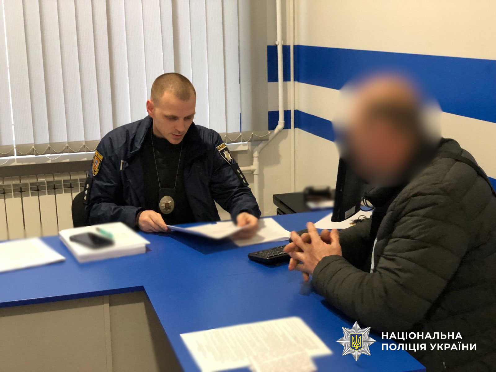 слідчий по справі в робочому кабінеті із підозрюваним