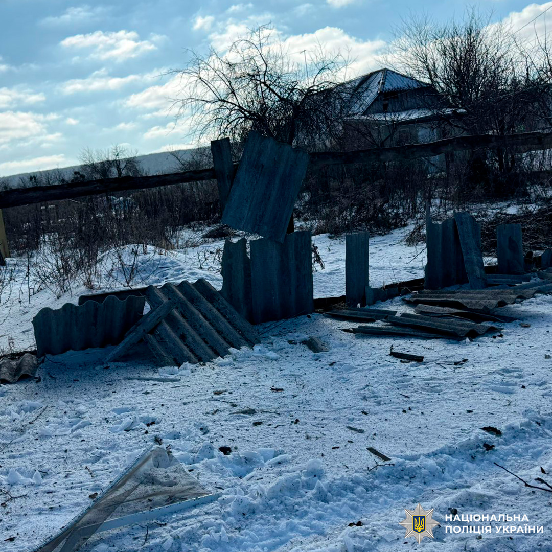 Засніжена територія з уламками металевого паркану, на задньому плані будинок із металевим дахом