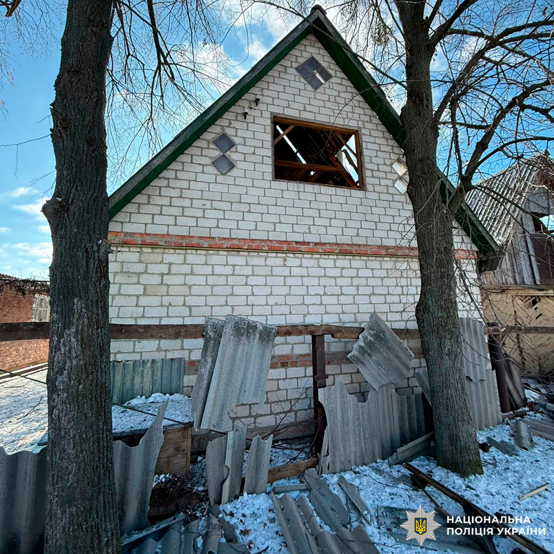 Пошкоджений цегляний будинок із вибитим верхнім вікном та зруйнованим парканом