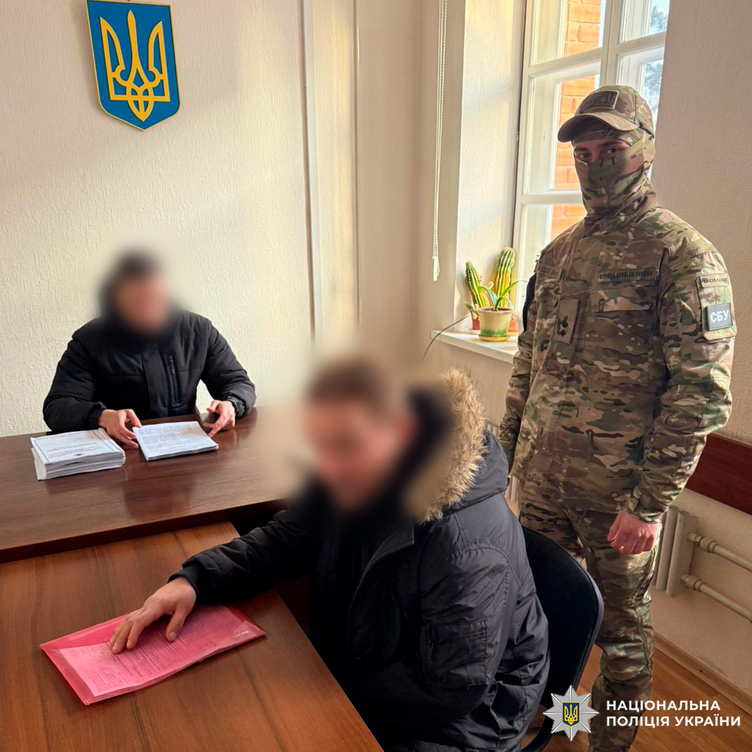 Співробітник СБУ та представники правоохоронних органів працюють із документами в офіційному кабінеті