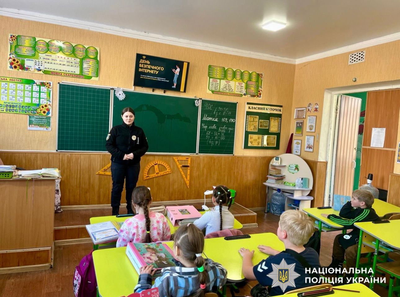 На фото зображено дітей та поліцейську