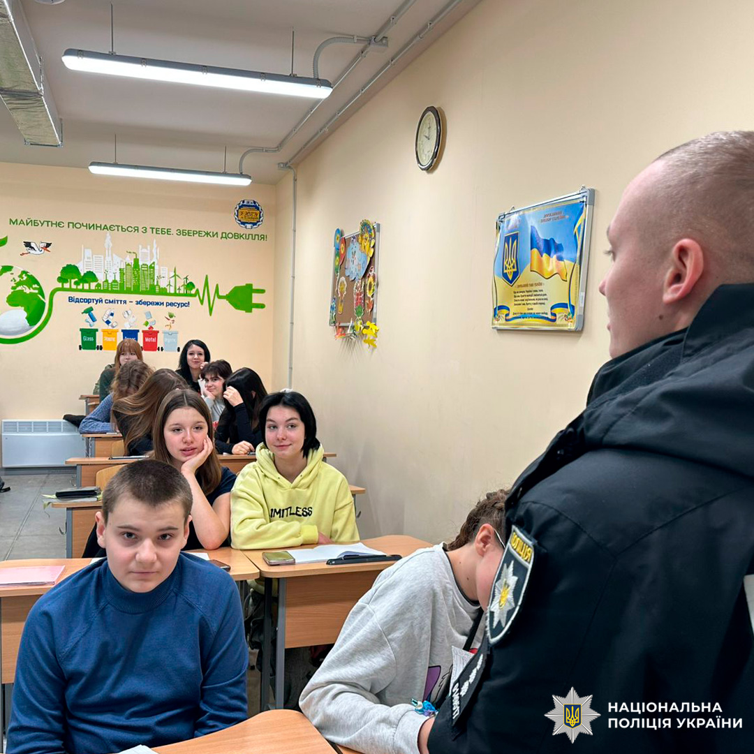 Учні сидять у класі, слухаючи виступ поліцейського