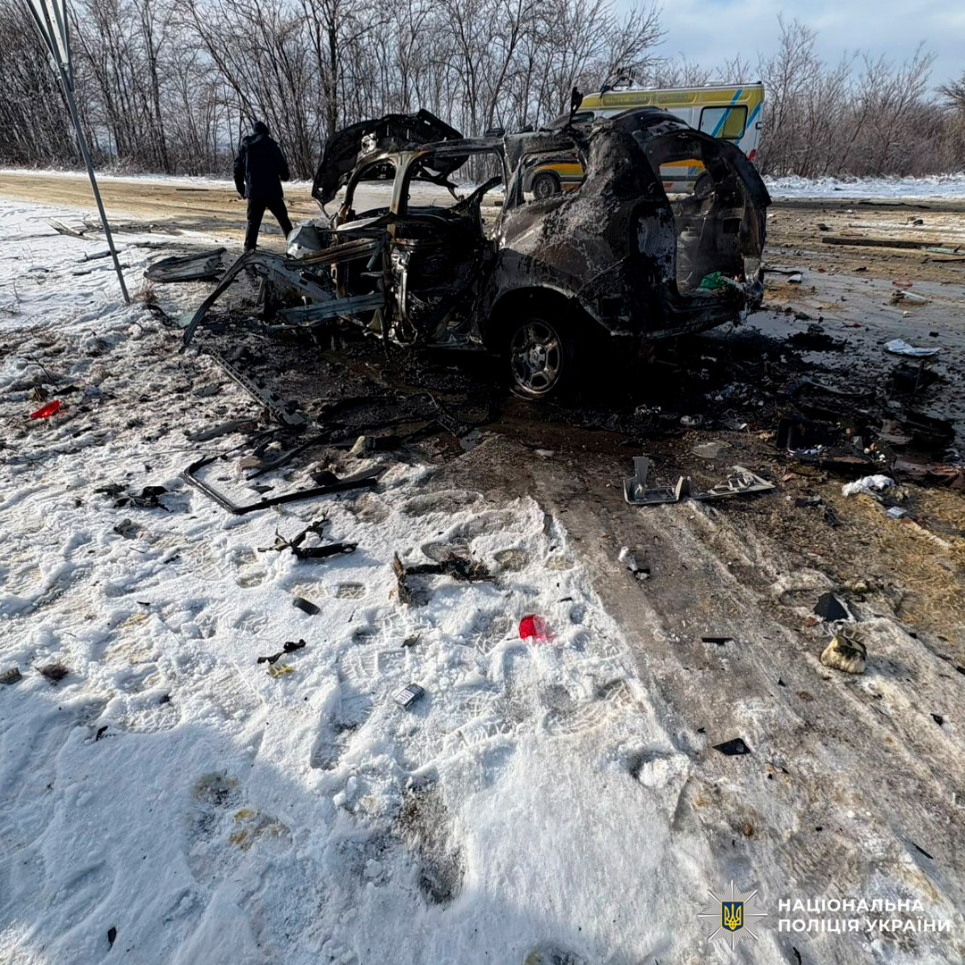 Пошкоджений та частково згорілий автомобіль, уламки розкидані по засніженій місцевості.